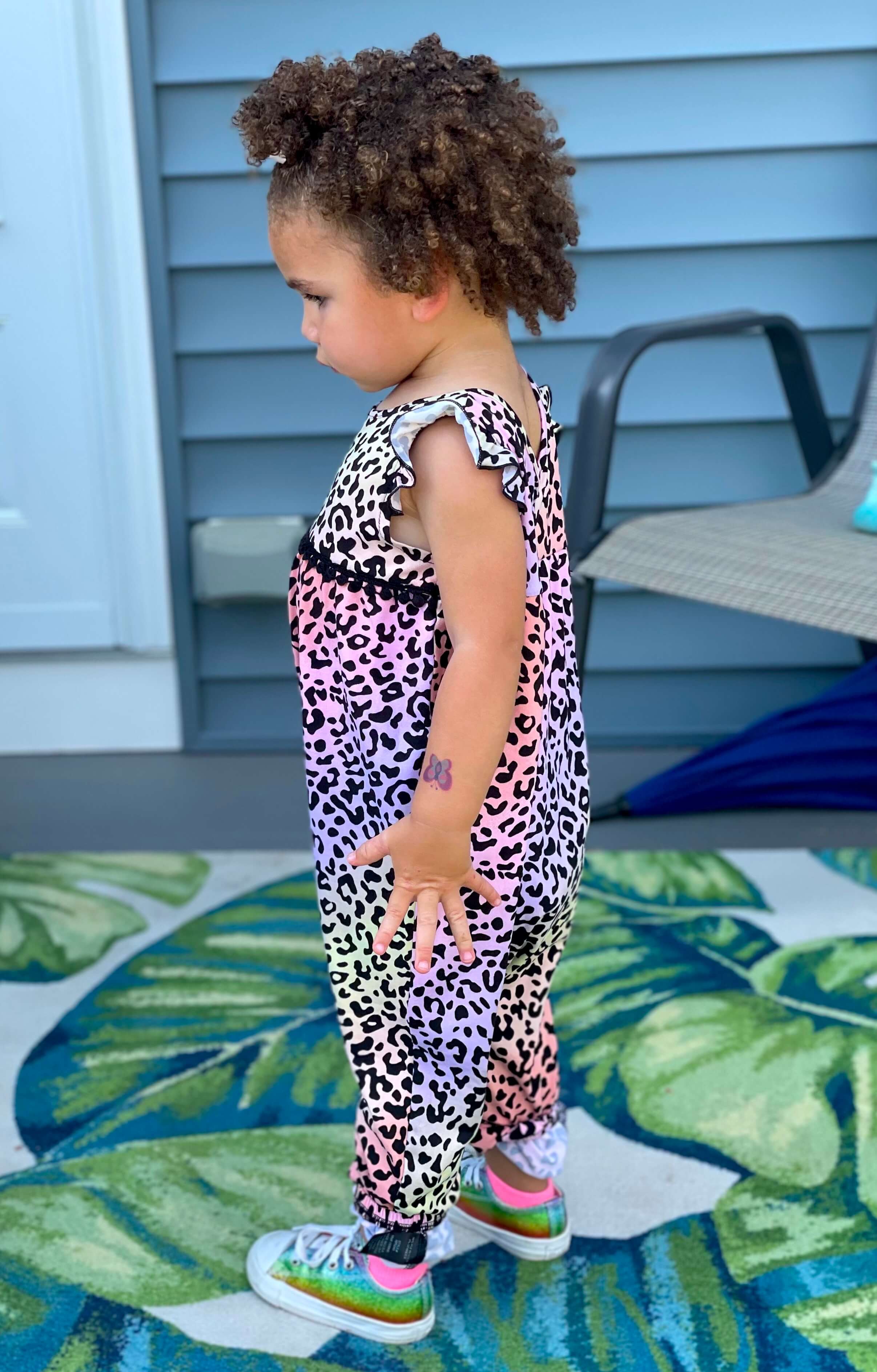 Young girl wearing a leopard print jumpsuit.