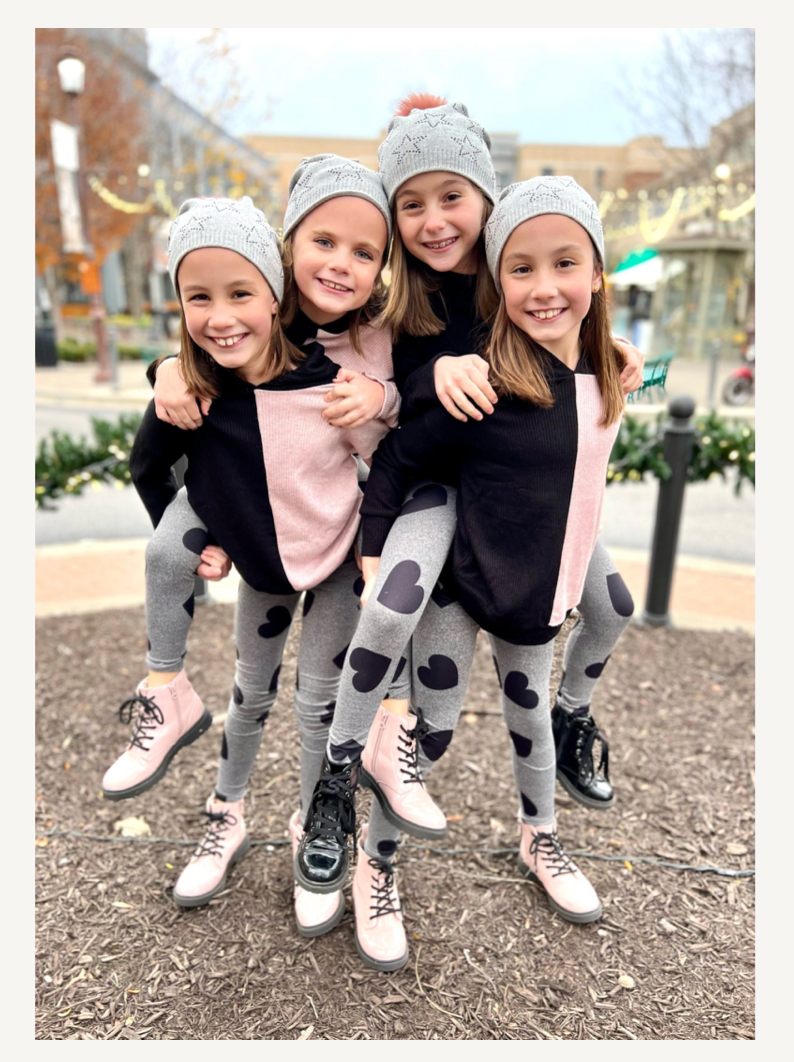 Four girls with beanies pink-black sweaters and grey heart leggings
