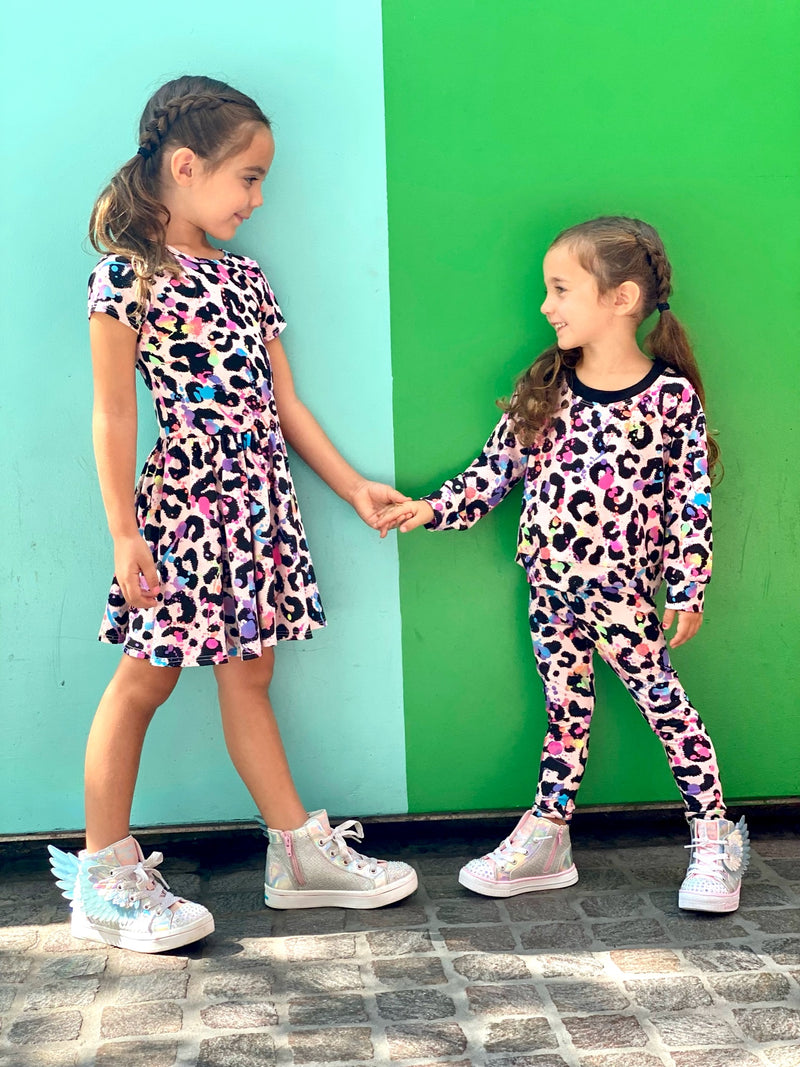 Two young girls wearing a matching pattern dress and sleepwear.